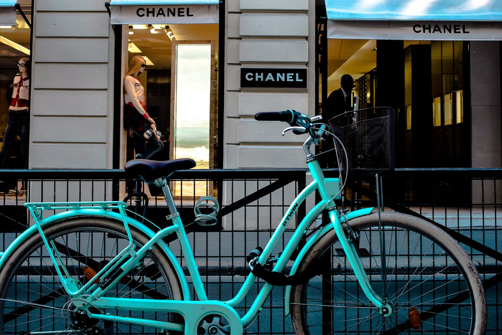 zielony rower stojący przed butikiem ekskluzywnej marki Chanel w centrum Paryża